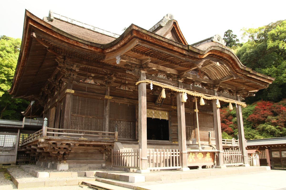 The worship hall of Kora Taisha in Kurume, with a straw rope and bells hung across the front.